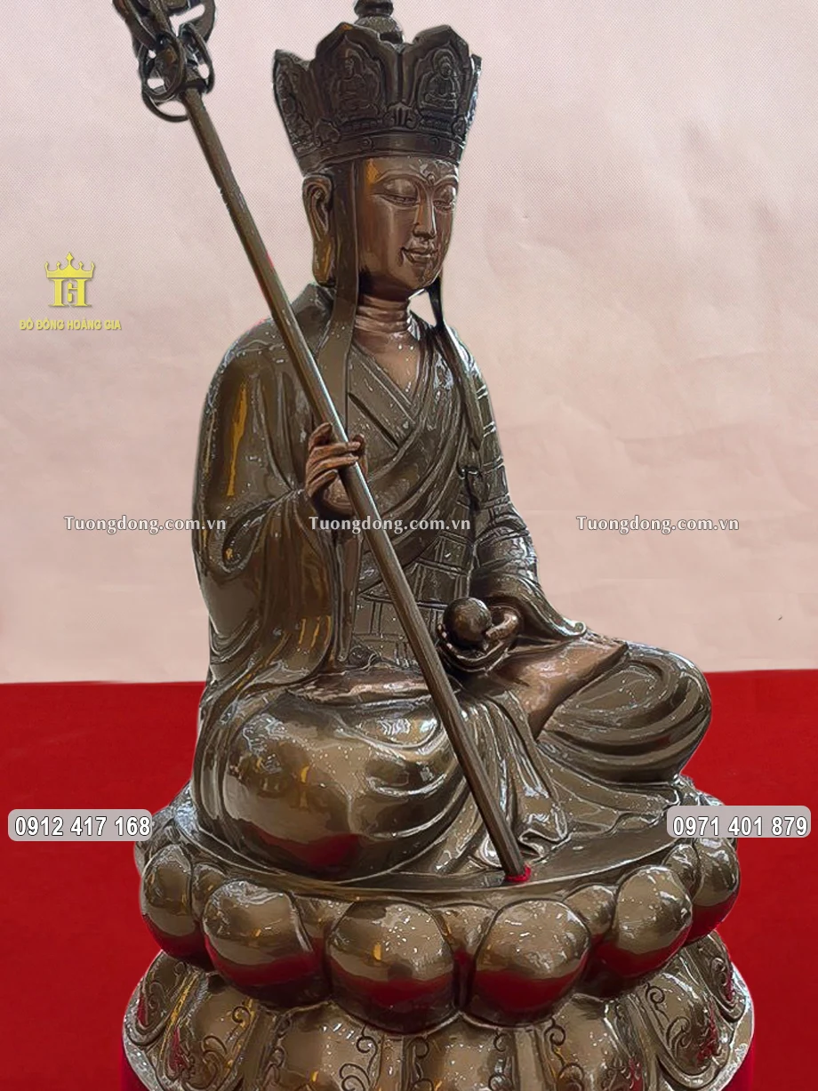 Tay phải Ngài cầm cây tích trượng